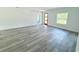 Bright living room with gray wood-look floors, a front door, and a window at 6421 Sw 151St Loop, Ocala, FL 34473