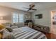 Cozy bedroom with a striped bedspread, ceiling fan, and a view of the backyard at 3076 Crane Strand Dr, Winter Park, FL 32792