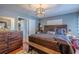 Well-decorated bedroom with a rustic wooden bed frame, matching dresser, and bedside table at 3076 Crane Strand Dr, Winter Park, FL 32792