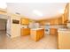 Spacious kitchen featuring tiled floors, center island, ample cabinets, and modern appliances at 516 Yellow Tail Pl, Chuluota, FL 32766