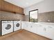 Laundry room with white cabinets, countertop, and new appliances at 5762 Emerington Cres, Orlando, FL 32819