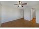 Bedroom featuring wood laminate flooring, ceiling fan, and ensuite bathroom access at 2533 Grassy Point Dr # 205, Lake Mary, FL 32746