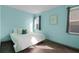 Bedroom with light teal walls and wood floors at 326 Highland Meadows Ave, Davenport, FL 33837