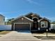 Charming single-story home featuring a two-car garage and inviting front entrance at 326 Highland Meadows Ave, Davenport, FL 33837