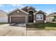 Two-story house with a two-car garage and landscaped lawn at 326 Highland Meadows Ave, Davenport, FL 33837