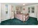 Bedroom features an antique gold bed frame, matching curtains, green carpet and lots of natural light at 10 Pilot Pl, Winter Haven, FL 33881