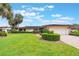 Charming one-story home with mature palm trees, manicured landscaping, and a brick-paved driveway at 10 Pilot Pl, Winter Haven, FL 33881