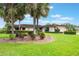 Front yard with large palm trees, lush landscaping, and a charming one-story home at 10 Pilot Pl, Winter Haven, FL 33881