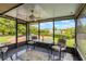 Enclosed lanai with ceiling fan, table and chairs overlooking a backyard with well manicured hedges at 10 Pilot Pl, Winter Haven, FL 33881