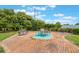 Cozy outdoor patio with brick pavers, lush green landscaping, a bench, and a table with chairs at 10 Pilot Pl, Winter Haven, FL 33881