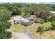 Expansive aerial view of the modern home with lush landscaping, circular driveway and screened pool area at 12550 Lakeshore Dr, Clermont, FL 34711