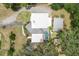 Overhead aerial view of modern home with screened pool and patio, surrounded by mature trees and lush lawn at 12550 Lakeshore Dr, Clermont, FL 34711