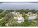 Aerial view showcasing waterfront property with lush trees and boat access at 12550 Lakeshore Dr, Clermont, FL 34711