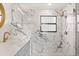 Modern bathroom featuring marble tiling, a glass shower, and a stylish vanity with gold fixtures at 12550 Lakeshore Dr, Clermont, FL 34711