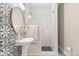 Charming bathroom featuring patterned tiles, glass shower, and gold mirror at 12550 Lakeshore Dr, Clermont, FL 34711