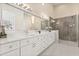 Spacious bathroom featuring double vanity, marble countertops, and glass shower at 12550 Lakeshore Dr, Clermont, FL 34711