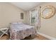 Small bedroom with cozy quilt, wood floors, and neutral paint at 12550 Lakeshore Dr, Clermont, FL 34711