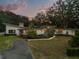 Charming exterior view of a modern home featuring well-manicured landscaping and a spacious driveway at 12550 Lakeshore Dr, Clermont, FL 34711