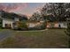 Striking single-story modern home boasting a well-kept lawn, tasteful landscaping, and mature shade trees at 12550 Lakeshore Dr, Clermont, FL 34711