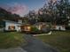 Beautiful single-story modern home featuring manicured landscaping, mature trees, and a long driveway at 12550 Lakeshore Dr, Clermont, FL 34711
