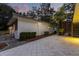 Back exterior showcasing a home with patio and tile, complemented by manicured bushes and lush greenery at 12550 Lakeshore Dr, Clermont, FL 34711