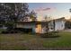 Well-maintained home exterior showcasing a manicured lawn and beautiful landscaping, set against a stunning twilight sky at 12550 Lakeshore Dr, Clermont, FL 34711