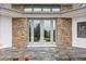Elegant front entrance with stone accents and tiled steps at 12550 Lakeshore Dr, Clermont, FL 34711