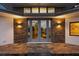 Stunning front entrance with stone accents, elegant double doors, and stylish outdoor lighting at 12550 Lakeshore Dr, Clermont, FL 34711