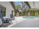 An enclosed pool sits outside with two blue lounge chairs at 12550 Lakeshore Dr, Clermont, FL 34711