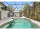 Clear screened-in pool surrounded by patio space and comfortable outdoor seating at 12550 Lakeshore Dr, Clermont, FL 34711