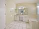 Bright main bathroom with dual sinks, vanity, tile floors, and a glass-enclosed shower at 12924 Lower River Blvd, Orlando, FL 32828