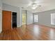 Spacious bedroom with wood floors, closet, two large windows, ceiling fan, and grey paint at 12924 Lower River Blvd, Orlando, FL 32828