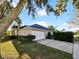 Charming single-story home featuring a two-car garage and lush landscaping at 12924 Lower River Blvd, Orlando, FL 32828