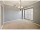 Bright, empty carpeted living room featuring neutral paint, a window, and chandelier at 12924 Lower River Blvd, Orlando, FL 32828