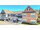 Row of townhomes with blue and orange siding, white picket fence and landscaping at 2203 San Vittorino Cir # 102, Kissimmee, FL 34741