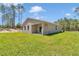 Backyard view showcasing the home's exterior, a green lawn, and natural surroundings at 13516 Sw 78 Pl, Dunnellon, FL 34432