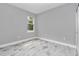 Cozy bedroom with wood-look tile flooring and a window offering a view of lush greenery at 13516 Sw 78 Pl, Dunnellon, FL 34432