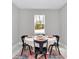Cozy dining room with a round table set for four, a traditional rug, and a serene view from the window at 13516 Sw 78 Pl, Dunnellon, FL 34432