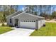 Single-story home with a two-car garage, walkway to the front door and manicured lawn at 13516 Sw 78 Pl, Dunnellon, FL 34432