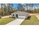 Aerial view of the house, surrounded by mature trees, a long driveway, and a well-maintained lawn at 13516 Sw 78 Pl, Dunnellon, FL 34432