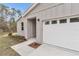 Close up of the front of a home showing vertical siding, a 2-car garage, and landscaped yard at 13516 Sw 78 Pl, Dunnellon, FL 34432