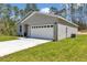 Home exterior showcasing a two-car garage, clean driveway, and green lawn at 13516 Sw 78 Pl, Dunnellon, FL 34432