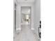 Inviting hallway showcasing light wood-look tile flooring, and an open view into the kitchen area at 13516 Sw 78 Pl, Dunnellon, FL 34432