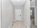 Clean, light-filled hallway featuring wood-look tile flooring and a crisp white entry door at 13516 Sw 78 Pl, Dunnellon, FL 34432