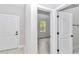 Bright hallway with wood-look tile floors and white doors leading to various rooms at 13516 Sw 78 Pl, Dunnellon, FL 34432