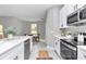Charming kitchen featuring stainless steel appliances, white cabinets, a dining area and view to the backyard at 13516 Sw 78 Pl, Dunnellon, FL 34432