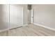 Bright bedroom features wood-look flooring, closet with bi-fold doors, neutral paint and white trim at 205 E 17Th St, Apopka, FL 32703