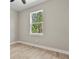 Bedroom with wood-look floors and a large window providing natural light and a view of mature trees at 205 E 17Th St, Apopka, FL 32703