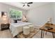Stylishly decorated bedroom with a plush bed, modern artwork, and a cozy rug, bathed in natural light from the window at 205 E 17Th St, Apopka, FL 32703