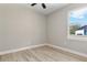 Bright bedroom featuring light hardwood floors and a ceiling fan, illuminated by natural light through the window at 205 E 17Th St, Apopka, FL 32703